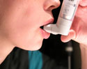 Photo of person using asthma inhaler