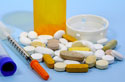 Photo of pills, pill bottle, and syringe