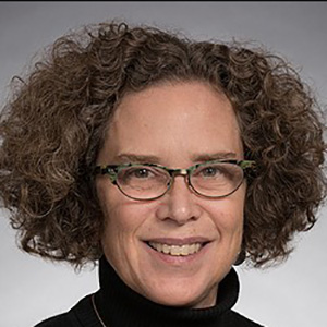 Profile picture of Nicole Gibran with curly brown hair and eyeglasses, smiling.