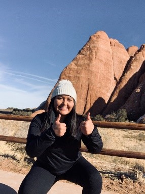 Mikenzie John outside in front of a rock formation.
