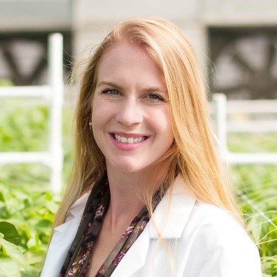 A headshot of Jenny Durrin in a greenhouse.
