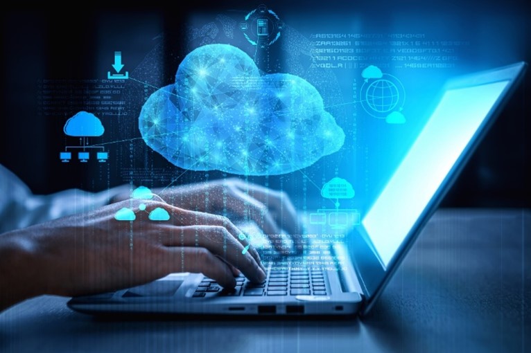 Hands typing on a laptop with a digitized cloud and computer icons floating above them.